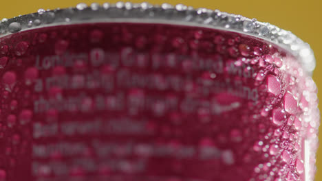 Close-Up-Of-Condensation-Droplets-On-Revolving-Takeaway-Can-Of-Cold-Beer-Or-Soft-Drink-Against-Yellow-Background-2
